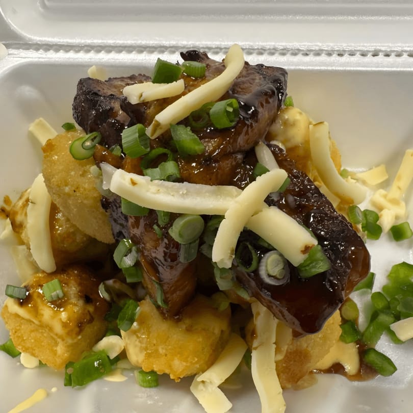 Close-up of Sharky's Island Bites poke dish with dark meat, cheese, and green onions.